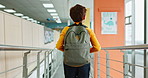 Back, child and backpack in walking, corridor and teenager for classroom, lesson or recess at campus or academy. Pupil, boy and growth for education, development and scholarship in learning or school