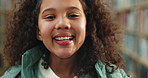 Face, girl and kid in library, smile and knowledge with fun, creativity and education. Portrait, child and student in school, youth and learning with confidence, pride and books with positive mindset
