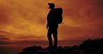 Sunset, mountain and shadow of man with hiking, view and nature with cliff fog and camping backpack. Outdoor, travel and adventure with journey, trekking and trip for wellness at dusk with silhouette