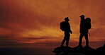 Men, sunset and silhouette on mountain for freedom, support and teamwork in dark. People, horizon and evening in nature for fitness, wellness and orange sky in environment for fresh air and travel