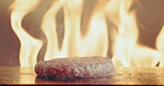 Fire, hand and patty for burger with chef in restaurant, cooking beef for cuisine, gourmet or meal. Flame, food and grill heat with person in kitchen for preparation of take away order closeup