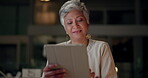 Corporate, mature woman and tablet at night in office, communication and company feedback. Dark, business professional and tech in workplace for international client, social media and chat in evening