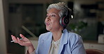 Mature woman, headset and online english teacher on computer at night in office for language lesson. Female person, night and video call with teaching on virtual class for distance education