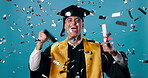 Man, confetti and celebration for graduation, diploma and achievement in college or education in studio. Graduate, happy and award for university, goal and certificate with success on blue background