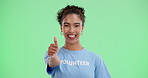 Volunteer, face and thumbs up with green screen and happy with woman, yes and emoji hand sign. Thank you, charity success and NGO worker with agreement, winning and achievement with smile in studio