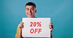 Sign, discount and face of man on blue background for 20 percent promotion, information and poster. Happy, advertising and portrait of person with banner for retail sale, deal and bargain in studio