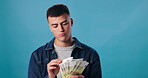 Face, profit and man with cash, finance and confident person on blue studio background. Portrait, guy and model with money, bonus and savings with investment, economy or counting with salary increase