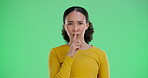 Green screen, face and woman with privacy for secret, silence and confidentiality of important information. Chromakey, female person and finger sign with reaction for shush, gossip and  whisper emoji