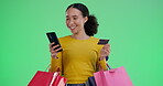 Woman, credit card and smartphone with shopping bags in green screen on studio for sale and discount. Female person, gifts and presents with internet rewards for subscription, payment and purchase