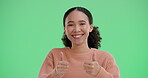 Woman, face and happy with thumbs up on green screen in studio for positive vote or review, agreement and affirmation. Girl, hand gesture and yes sign for approval, well done and good reputation.