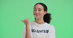 Smile, woman and point for volunteer on green screen with ngo advertising, show direction and charity service. Happy, female person and sideways gesture for recruitment support,  donate or fundraiser