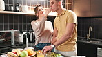 Couple, cooking and taste in home kitchen with fruit salad, breakfast and bonding with support. Love, people and grapes brunch for nutrition, healthy food and meal preparation for wellness and care