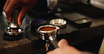 Coffee, tamper and hands of person with ground beans for premium drink at small business restaurant. Machine, tools and barista pressing espresso powder in filter for morning brew in cafe service