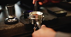 Coffee, portafilter and hands with person in cafe, waiter and barista service with employee for caffeine process. Grounded beans, metal stirrer and smoothing out or mixing, roasted blend and counter