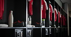 Gym, interior and empty locker room with sport jersey, water bottle and fitness equipment. Soccer, change and uniform at club with clothes, shoes and football cleats in dressing closet for storage