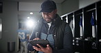 Black man, football coach and tablet with team in locker room for strategy, game plan or sports news. African mentor, athlete or trainer scrolling or browsing on technology before match or playoffs