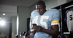 Football, player and man with cellphone, typing and social media in locker room, texting and app. Person, sports or guy with smartphone, mobile user or internet with connection or message for contact