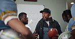 Man, football coach and meeting with team for game plan, strategy or discussion on formation in locker room. Male person or mentor talking to athletes or sport players for offense, defense or playoff