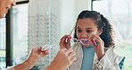 Helping, woman and glasses for child, smile and vision for girl, fitting and happy with option of healthcare. Shopping, customer and eyewear in shop, optician and employee with choice for kid