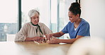 Chess, senior woman and nurse playing at table for moving, strategy or board game challenge. Solution, decision and elderly person with caregiver for cognitive skills, tactics or retirement home