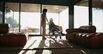 Caregiver, support and senior man with wheelchair for rehabilitation, help and afternoon sun by window. Retirement home, woman and person with disability for mobility assistance, recovery and service