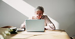 Senior woman, laptop and glasses in home for finances, travel planning and budget with notebook. Elderly person, computer and spectacles at table for online banking, flight research or insurance info