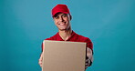 Delivery man, face or box in studio for client, distribution service and supplier on blue background. Confident, supply chain and portrait of happy courier worker giving shipping package or goods