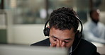 Headache, stress and man in call center office for customer service, consulting and business crm. Advisor or agent, inbound telemarketing and tired for listening, communication and faq support.