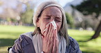 Tissue, senior woman and sneeze with flu, outdoor and retirement with illness, sick and cold. Pensioner, park and old lady with covid symptoms, blowing nose and fever with allergy and health problem