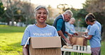 Portrait, mature woman and volunteer with box in nature, donation and contribution for community service. NGO, smile and female member in park with pride, charity or package for social responsibility