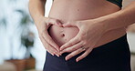 Woman, pregnant and heart hands in home for care, future and love for unborn baby. IVF healthcare, expecting mom or holding abdomen with pilates for wellness, healthy body or childcare in living room