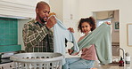 Dad, child and folding clothes in home for house work, learning chores and bonding together. Father, young daughter and helping with laundry in kitchen for cleaning, development and weekend routine