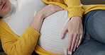 Pregnant, stomach and hands of woman on sofa for wellness, maternity health and breath in home. Pregnancy, parenting and person touch tummy for comfort, love and care for motherhood in living room