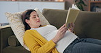 Pregnant woman, relax and book for reading on sofa with information, knowledge and wellness. Future mama, home and literature for pregnancy education, fetal development and advice for newborn care