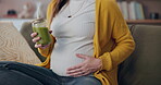 Pregnant, woman and home on sofa with green juice for nutrition,  digestive health and wellness. Female person, mother and healthy beverage or home made for vitamins and boost immune system