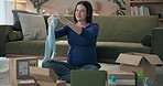 Home, pregnant and woman with baby clothes in boxes for unpacking, sorting and online shopping. Female person, mother and happy or smile in living room with gifts or present from baby shower