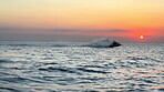 Sunset, sky and person at beach with watercraft for tropical adventure, fun activity and recreation in Zanzibar. Ripples, water sport and tourist on boat in ocean, travel location and summer vacation