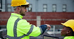 Business people, technician and discussion with helmet on rooftop for solar panel installation, building or project at site. Contractor or civil engineer talking to colleague on renewable energy