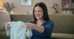 Happy, pregnant and woman with baby clothes for unpacking, sorting and shopping. Female person, mother and home with smile in living room on floor with gifts or present from baby shower with joy