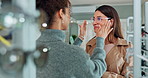 Eye care, woman and customer with glasses in store for help with frame choice, decision and eyewear option. Optometry, optician and person with shopping for prescription lens, spectacles and advice