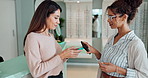 Women, optometrist and happy with customer digital payment for glasses or consultation at shop. People, doctor and smile with client for prescription or frame with electronic purchase for eye care