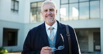 Mature man, professor and portrait at graduation for knowledge, education and pride for class success. Male lecturer, glasses and smile on campus for event, professional and shared wisdom at building