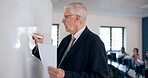 Teacher, man and writing on whiteboard for education, curriculum or learning change with paper. Mature lecturer, board and teaching in university with foreign students on computer for english lesson