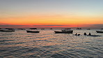 Sunset, ocean and boat with silhouette of scuba diver group on outdoor travel adventure on island vacation. Sky, sailing and people in water on tropical diving holiday with calm sea in marine tourism