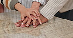 Family, trust and hands together for support in home with fun activity, unity or love on table in dining room. Closeup of parents, children or piling for protection, collaboration or bonding in house