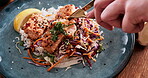 Person, restaurant and hands with food for eating meat, fine dining and supper on dish for nutrition. Closeup of knife, fork and cutlery with meal preparation for stir fry chicken, health and dinner