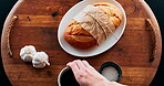 Bread tasting station, ingredients and above with food hand and time lapse with healthy meal. Person, closeup and chef with recipe, garlic and break with salt, black pepper corns and wooden board