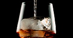 Glass, whiskey and ice with closeup, alcohol and bourbon on black studio background. Empty, cold and smooth drink with refreshment, pouring and cube with scotch, luxury and liquor with rum and cognac