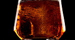 Glass, whiskey and ice with double, alcohol and bourbon on black studio background. Empty, cold and smooth drink with refreshment, pouring and cube with scotch, luxury and liquor with rum and brandy