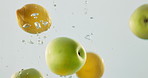 Fruit, mix and vitamin c with water splash in natural nutrition, fresh produce or hydration in studio on a white background. Closeup of apple, lemon or citric acid of wet organic food in healthy diet